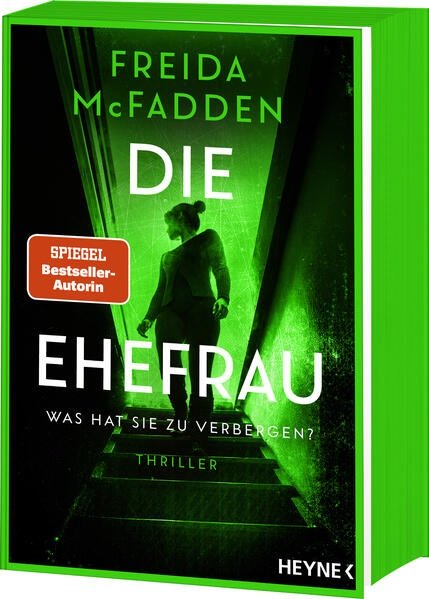 Eine Frau am oberen Absatz einer Treppe die sich nach hinten umsieht.